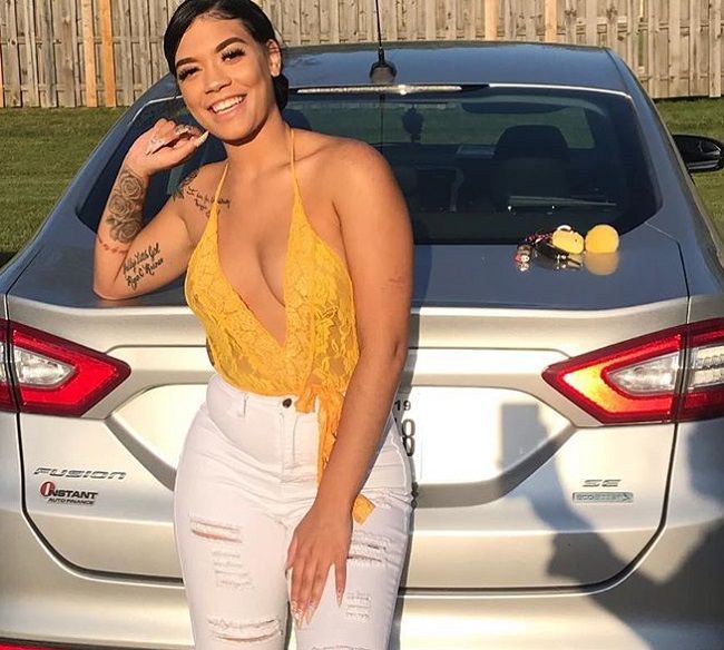 Caption: Alexis Raines captured posing with her car (Source: Instagram) .