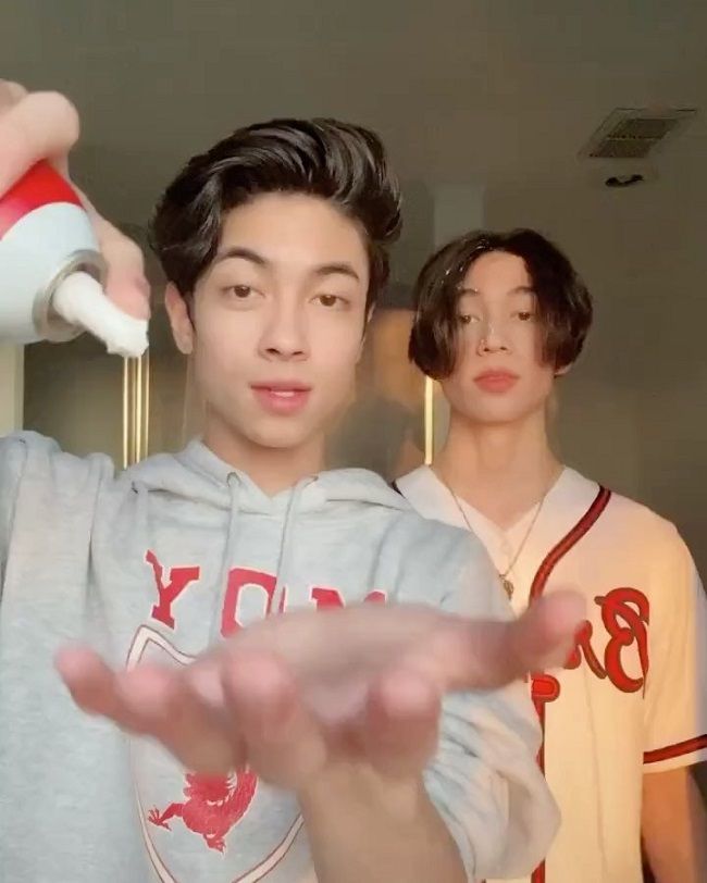 Caption: Oliver Moy and his brother while making a TikTok video. 