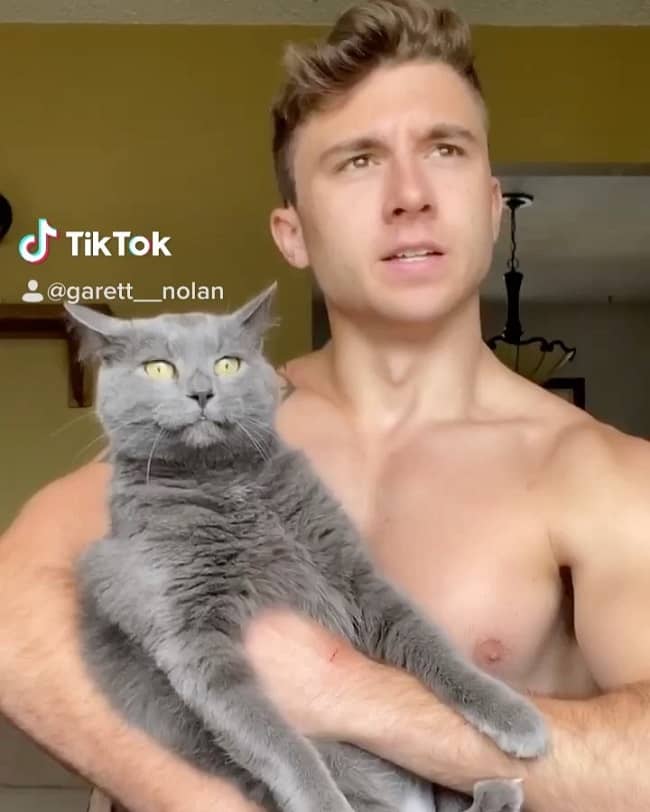 Caption: Garett Nolan making a TikTok video with his pet cat. 